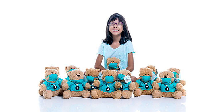 Gianna and a large group of stuffed Dr. Goodbears.
