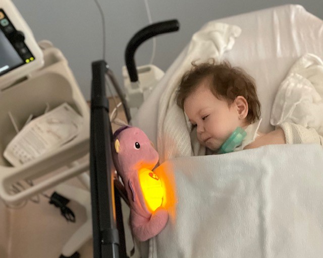Aly in hospital bed with night light.