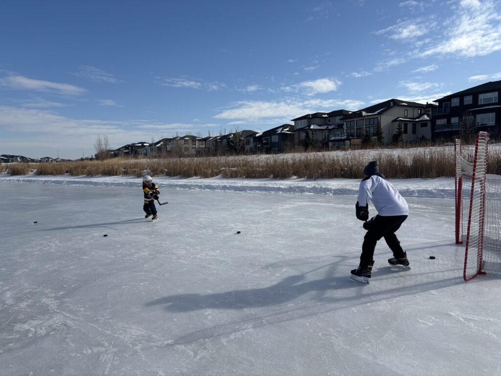 Jack playing pond hockey with his dad.