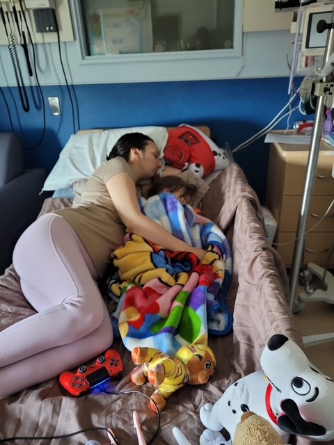 Camille and Ella sleep together in Ella's hospital bed