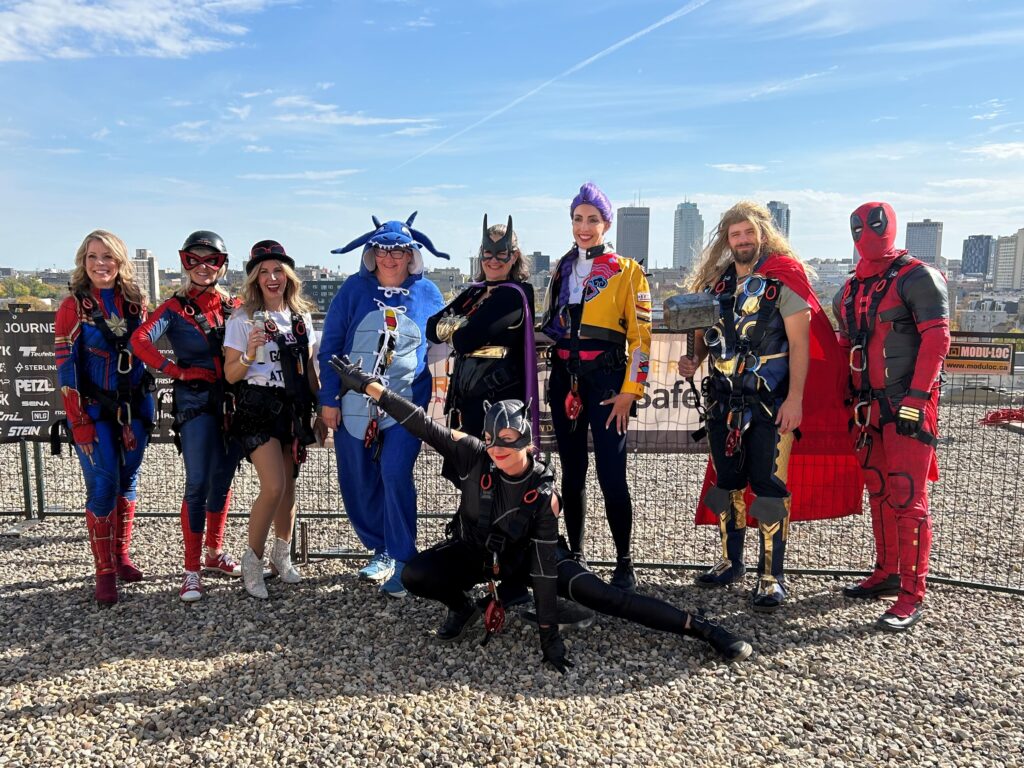 Fundraisers dressed as superheroes pose on the roof of the children's hospital