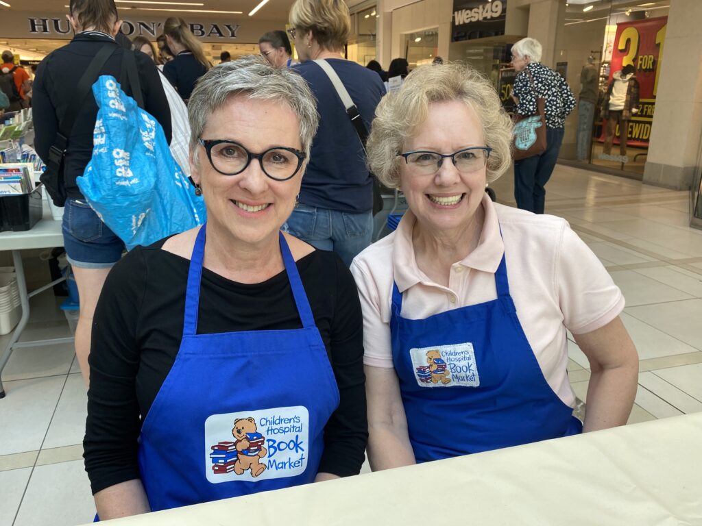 Two volunteers help out at the Children's Hospital Book Market.