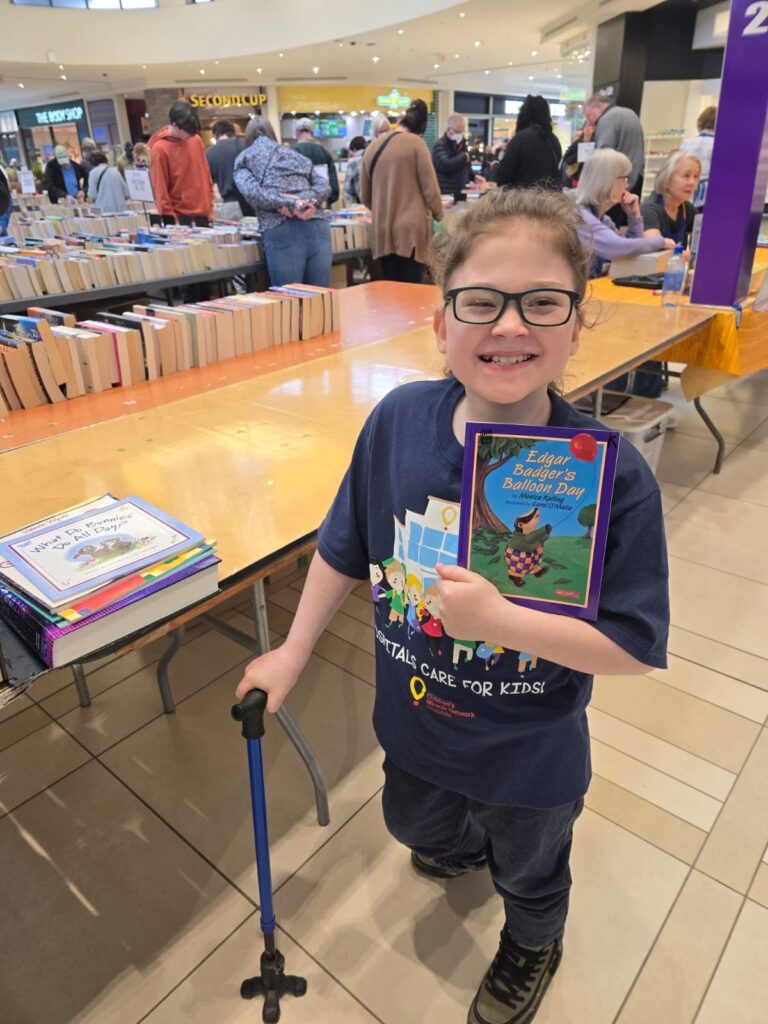 Jack holds a book at the Children's Hospital Book Market.