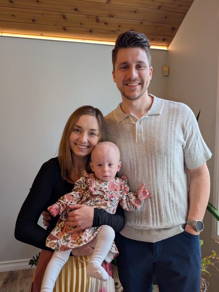Cassidy holds baby Juliette and stand next to Patrick in their home.