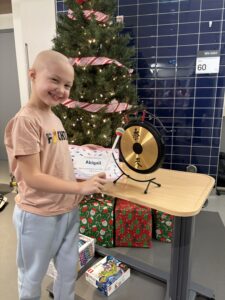 Abby hits a gong to celebrate completing her last chemo admission.