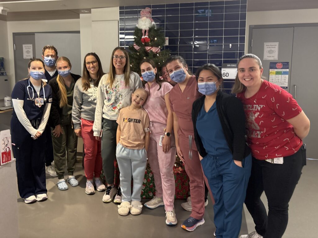 Abby poses with her health care team.