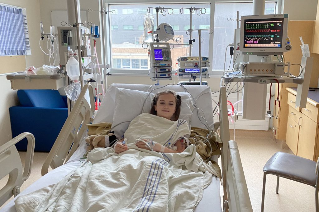 Cloe in her hospital bed recovering from surgery to remove her brain tumour.