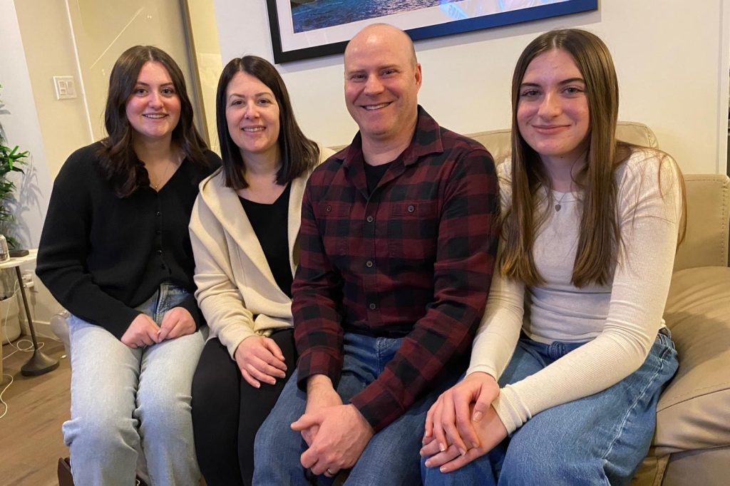 Cloe and her family sitting on a couch.